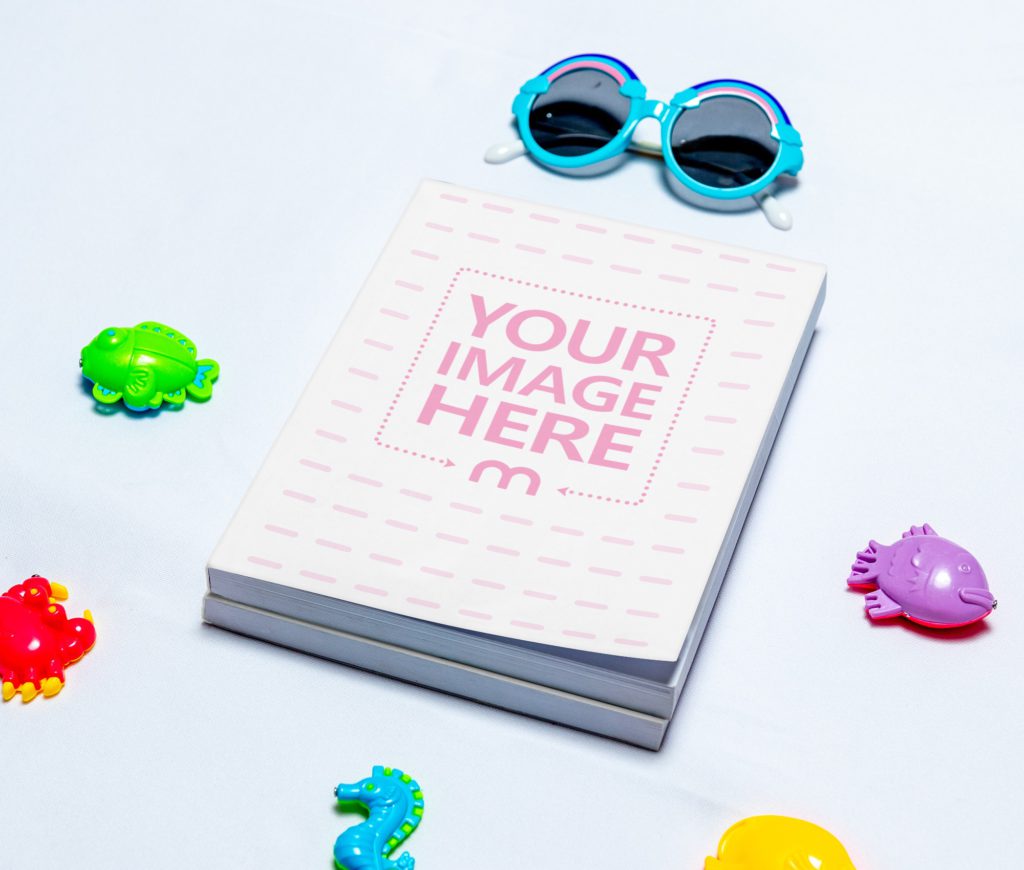 Two books on top of each other around the game sea animals and sunglasses.