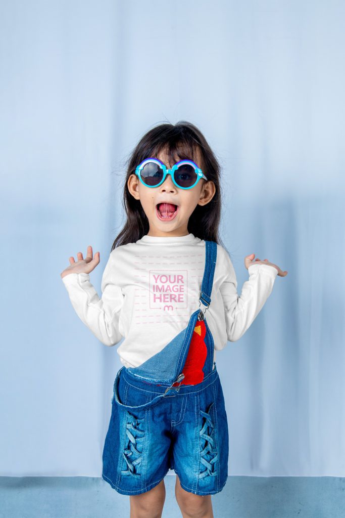 happy girl is wearing jeans and a shirt. she is wearing sunglasses.